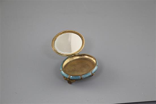 A late 19th century gilt metal and enamel oval box, decorated with a basket of flowers,